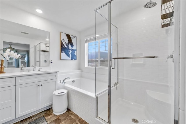 bathroom featuring a shower stall, a bath, and vanity