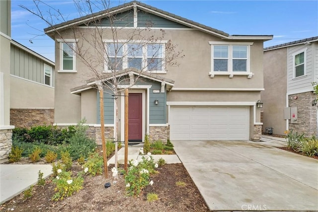 craftsman house with stucco siding, driveway, stone siding, and a garage