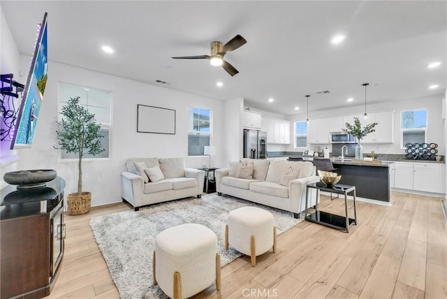 living area featuring a ceiling fan, visible vents, recessed lighting, and light wood-style floors