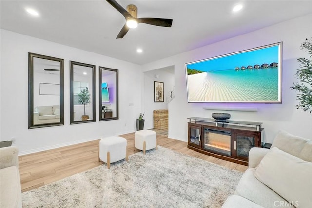 living room featuring baseboards, a ceiling fan, wood finished floors, and recessed lighting