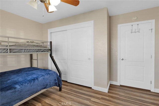 bedroom featuring hardwood / wood-style flooring, ceiling fan, and a closet