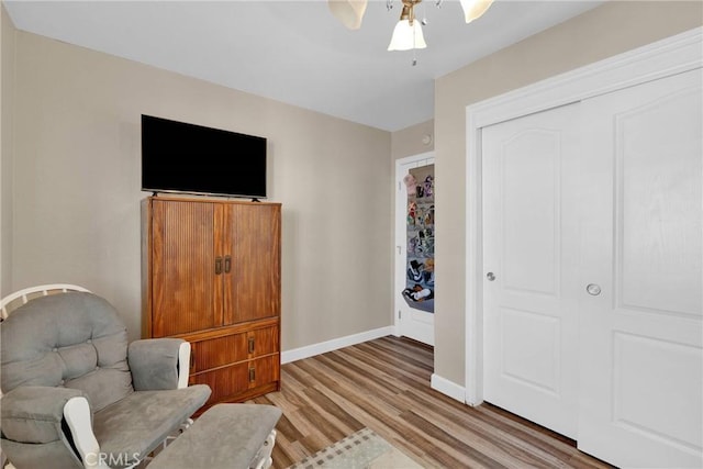 living area with ceiling fan and light hardwood / wood-style flooring