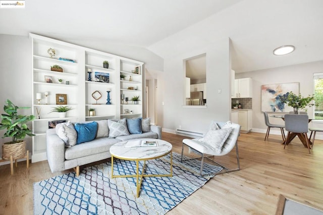 living room featuring vaulted ceiling, light hardwood / wood-style floors, and a baseboard heating unit