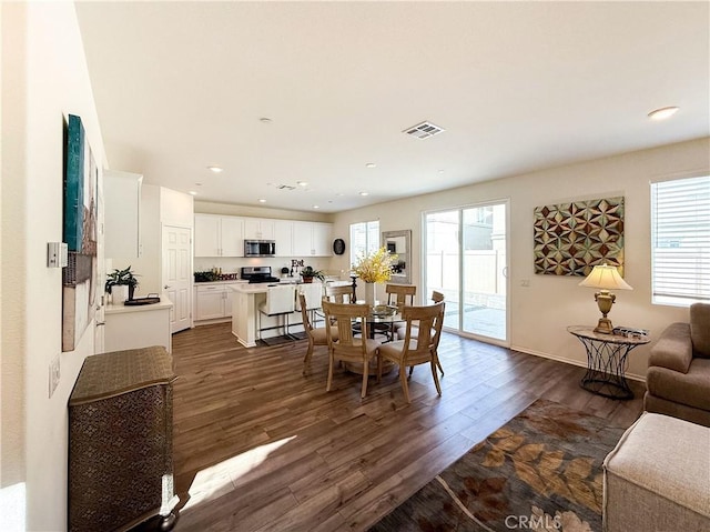 dining area with a healthy amount of sunlight and dark hardwood / wood-style flooring