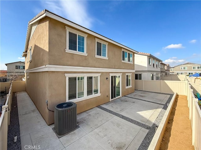 rear view of property with cooling unit and a patio