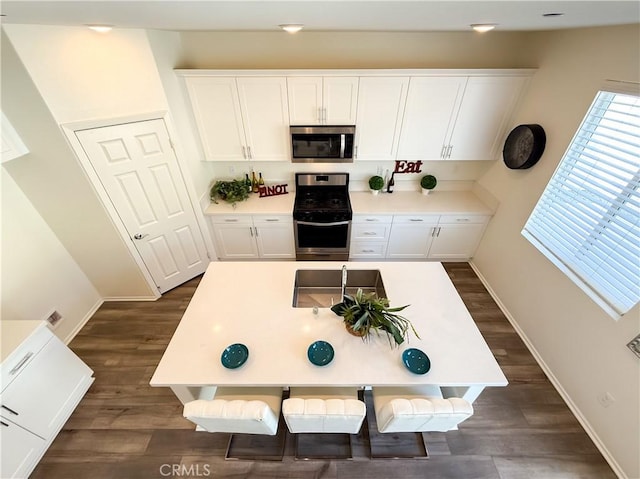 kitchen featuring white cabinetry, stainless steel appliances, and dark wood-type flooring