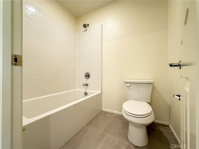 bathroom with tile patterned flooring, tiled shower / bath combo, and toilet