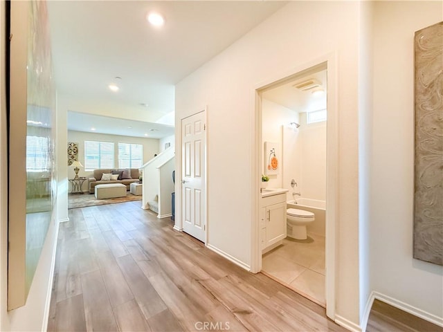 corridor with light hardwood / wood-style floors