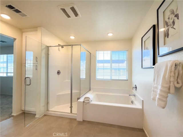 bathroom with tile patterned flooring, separate shower and tub, and a wealth of natural light