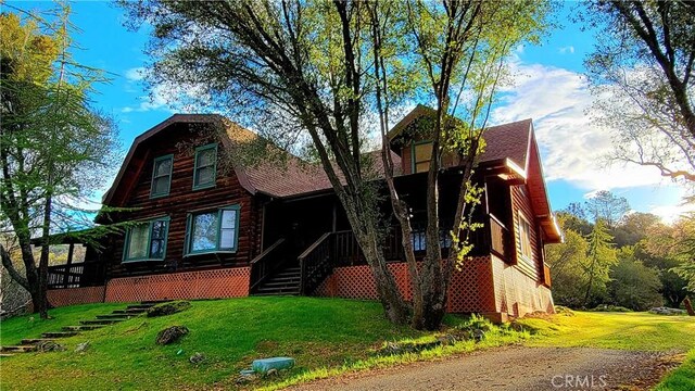 log home featuring a front lawn