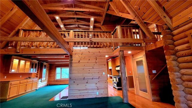 unfurnished living room with beamed ceiling, hardwood / wood-style flooring, wooden ceiling, and high vaulted ceiling