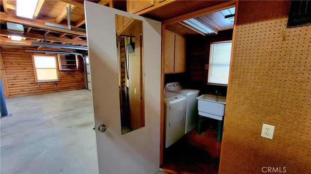 laundry area featuring sink, washing machine and dryer, and cabinets