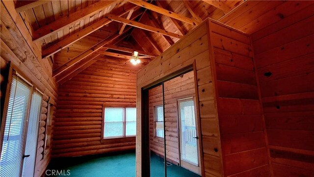 interior space with log walls, lofted ceiling with beams, carpet, and wooden ceiling