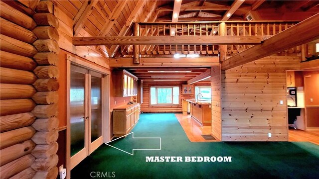 interior space with sink, rustic walls, high vaulted ceiling, light hardwood / wood-style floors, and wooden ceiling