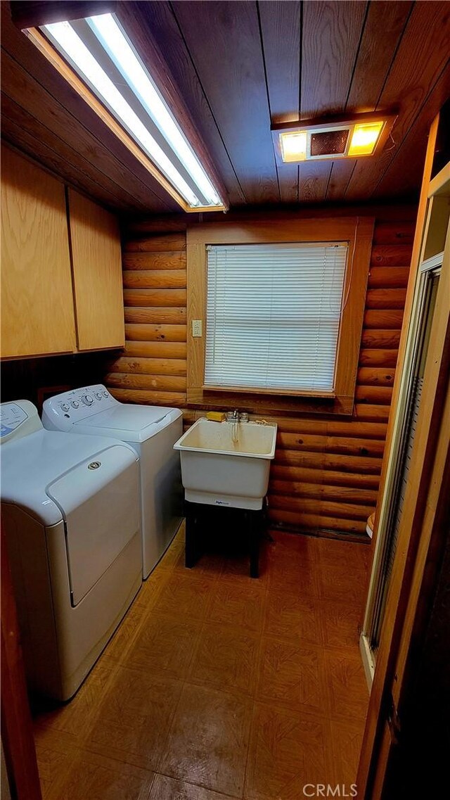 laundry room featuring sink, cabinets, separate washer and dryer, wooden ceiling, and log walls