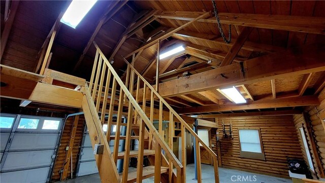 stairs with lofted ceiling and log walls