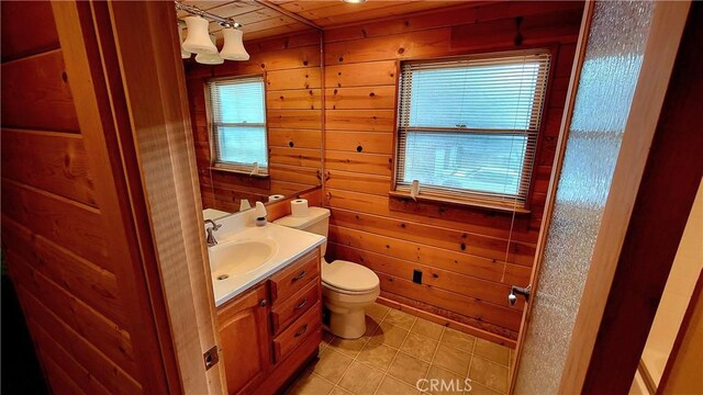 bathroom featuring wood walls, tile patterned flooring, vanity, wood ceiling, and toilet