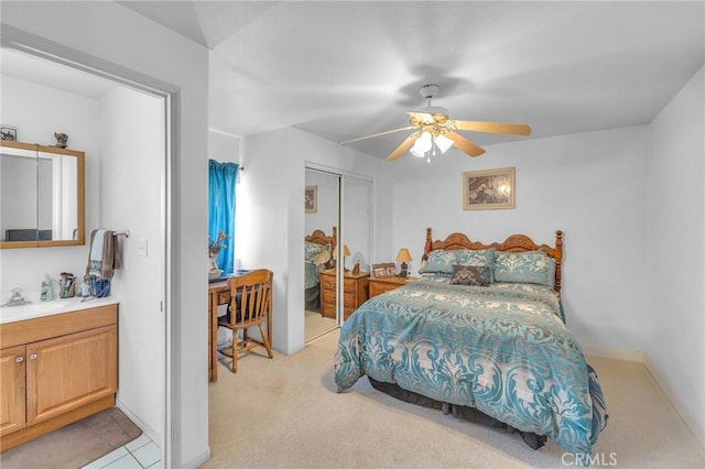 carpeted bedroom with sink, a closet, and ceiling fan