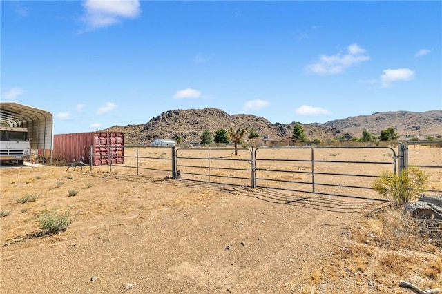 view of yard with a rural view, a mountain view, and a carport