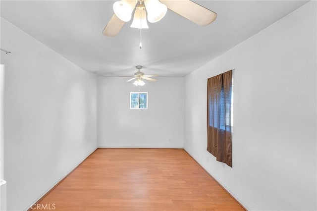 empty room with ceiling fan and light hardwood / wood-style flooring