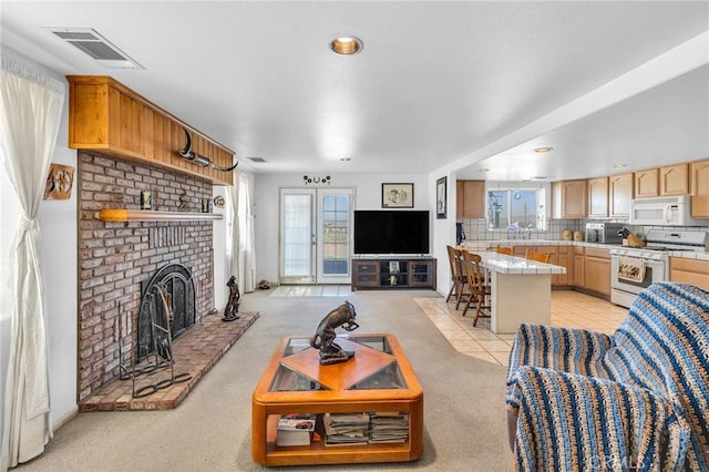 carpeted living room featuring sink and a fireplace