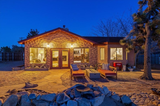 rear view of property with french doors, a patio area, and a fire pit