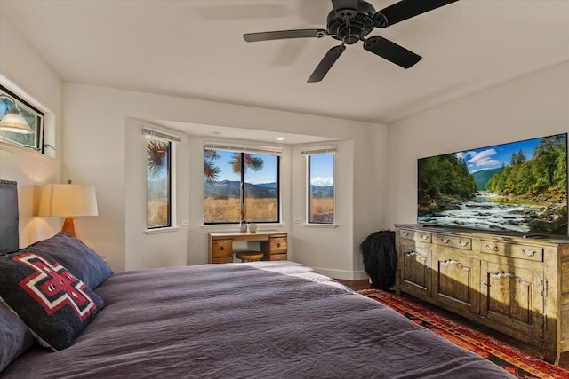 bedroom with dark hardwood / wood-style flooring and ceiling fan