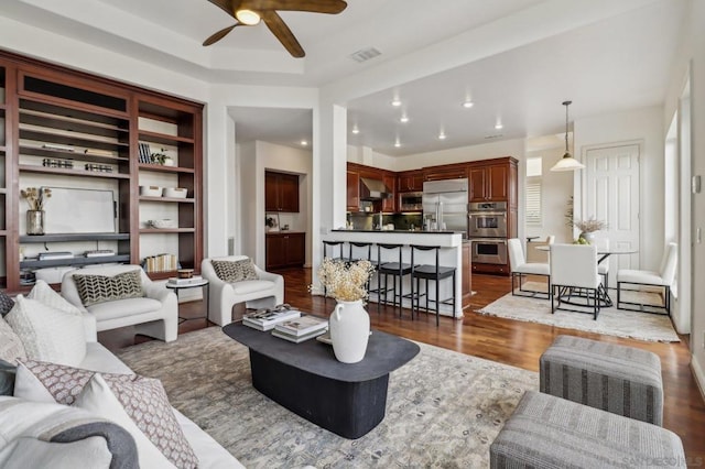 living room featuring dark hardwood / wood-style flooring and ceiling fan