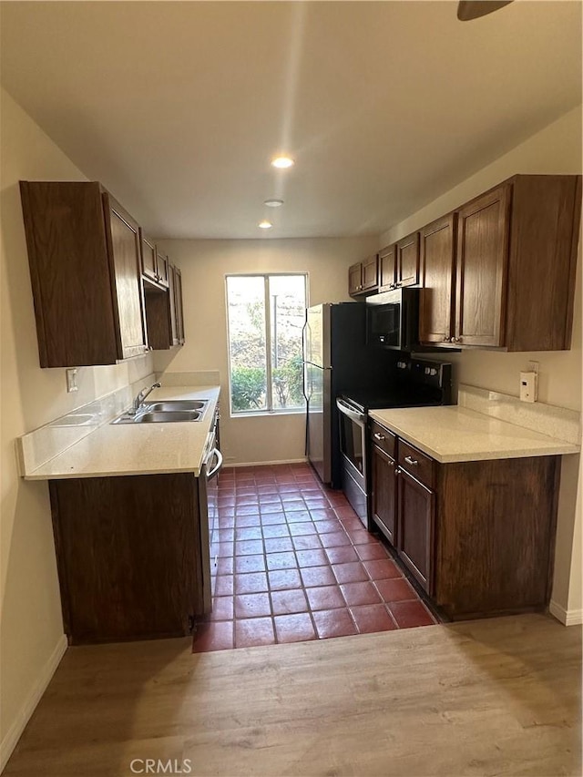 kitchen featuring dark brown cabinetry, sink, and stainless steel appliances