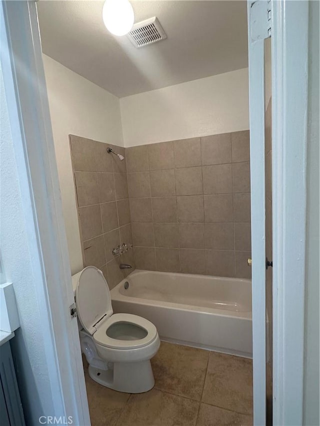 full bathroom featuring tile patterned flooring, vanity, tiled shower / bath combo, and toilet