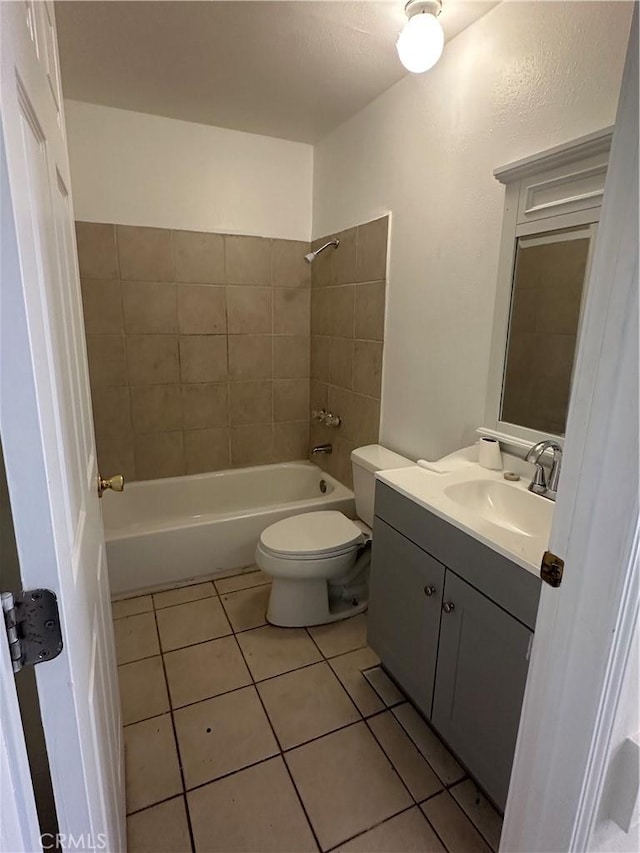 full bathroom featuring vanity, tile patterned flooring, tiled shower / bath combo, and toilet