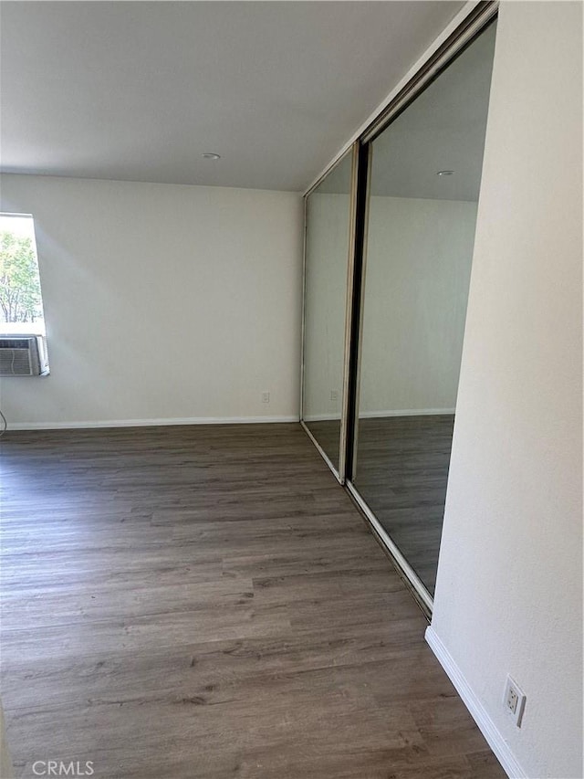 unfurnished bedroom featuring dark wood-type flooring and a closet