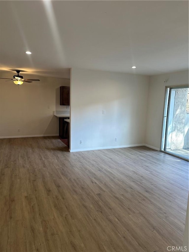 unfurnished living room featuring ceiling fan and light hardwood / wood-style flooring