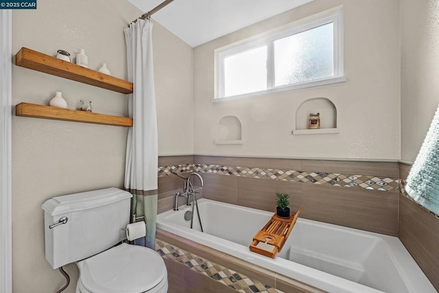 bathroom featuring a relaxing tiled tub and toilet