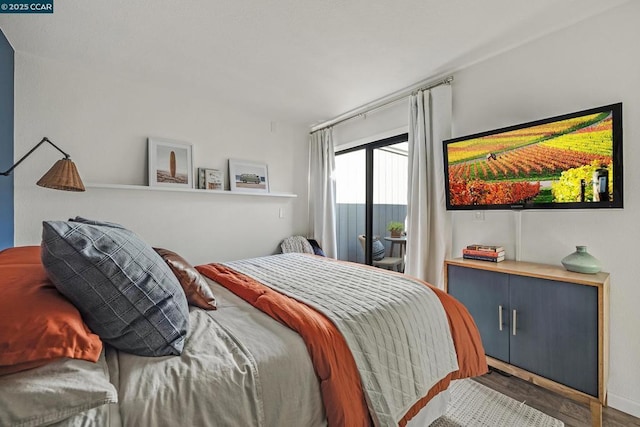 bedroom with access to exterior and dark wood-type flooring