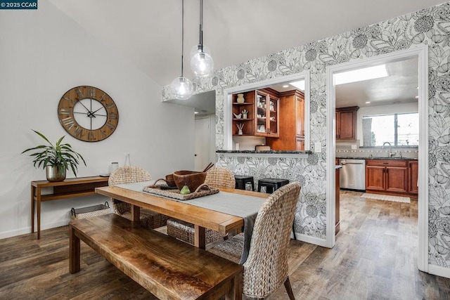 dining space featuring lofted ceiling, sink, and wood-type flooring