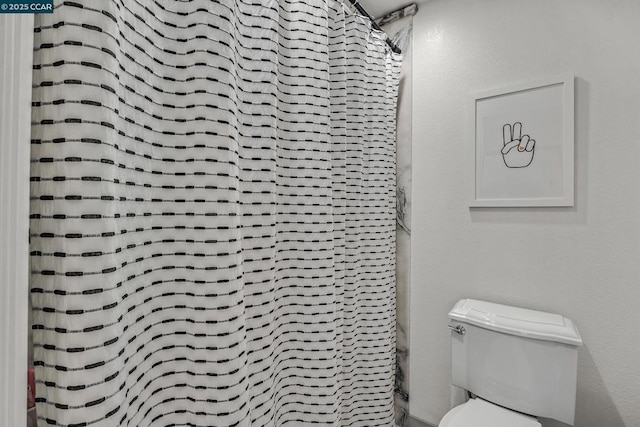 bathroom with a shower with curtain and toilet