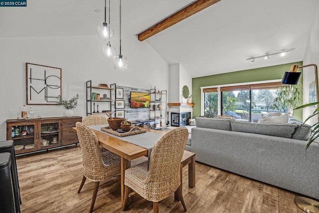 dining area featuring beam ceiling, wood-type flooring, high vaulted ceiling, and rail lighting