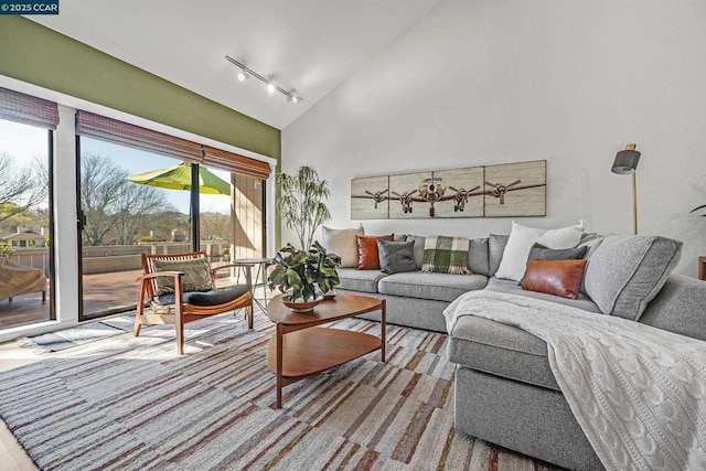 living room with track lighting and high vaulted ceiling