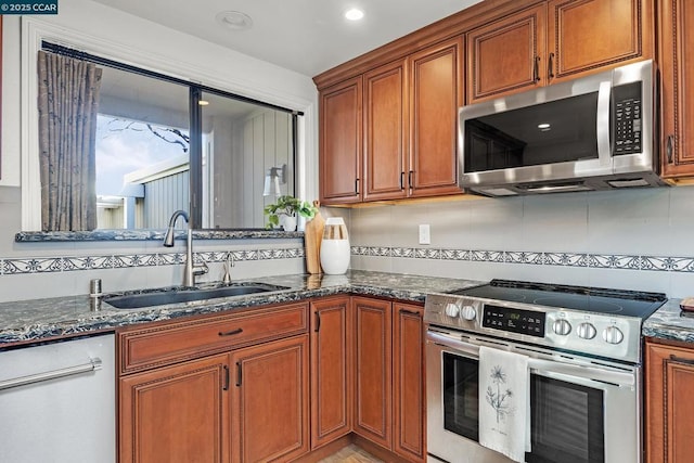 kitchen featuring dark stone countertops, sink, backsplash, and appliances with stainless steel finishes