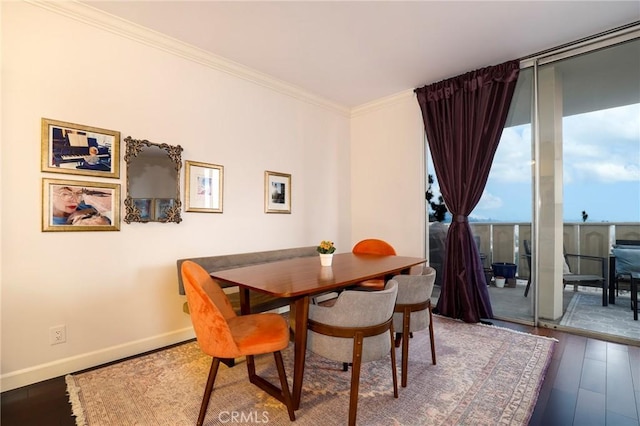 dining room with crown molding, wood-type flooring, and expansive windows