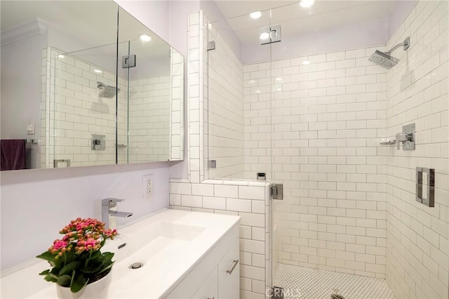 bathroom featuring walk in shower, vanity, and crown molding