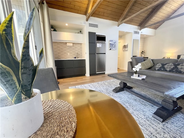 living room featuring vaulted ceiling with beams, wood ceiling, and light wood-type flooring