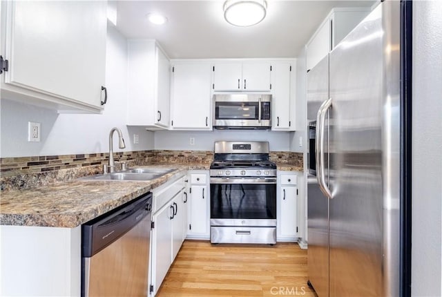 kitchen featuring white cabinetry, appliances with stainless steel finishes, sink, and light wood-type flooring