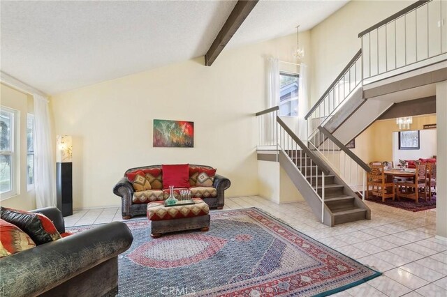 living room with an inviting chandelier, beam ceiling, high vaulted ceiling, and light tile patterned floors