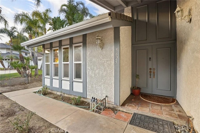 doorway to property featuring stucco siding