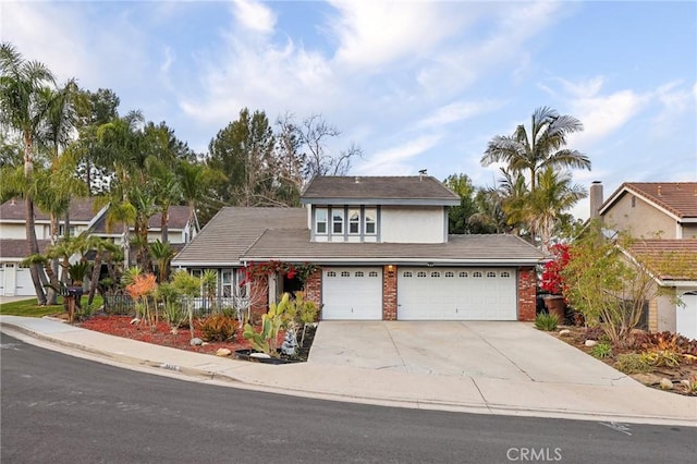 traditional-style house with a garage, brick siding, and driveway