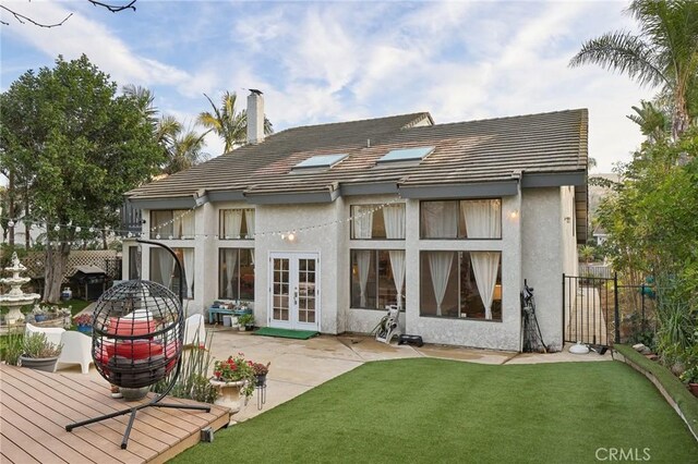 back of house with french doors, a yard, a wooden deck, and a patio area