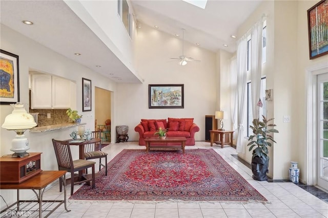 living area with recessed lighting, a high ceiling, light tile patterned flooring, and a ceiling fan