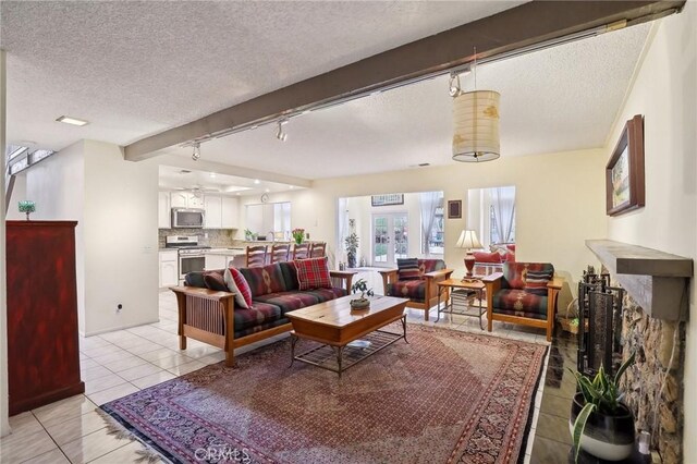 tiled living room featuring beam ceiling, a textured ceiling, and rail lighting